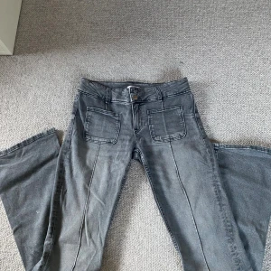 Grå Jeans - Grå, låg midja, bootcut och fickor både fram och bak från Gina. De är i bra skick. 