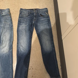 Blå Replay hyperflex anbass - Snygga blå jeans från Replay med klassisk femficksdesign och raka ben. Jeansen har slitningar och ljusare partier framtill för en cool, använd look. Perfekta för dig som gillar en tidlös och avslappnad stil.