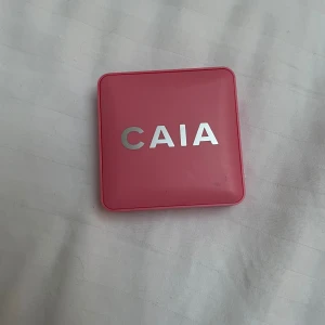 CAIA Matte Blush Troublegum - Säljer CAIA Matte Blush i färgen Troublegum. Rougen kommer i en snygg rosa fyrkantig dosa med spegel och har en matt, bubbelgumsrosa nyans. Perfekt för att ge kinderna en fräsch och ungdomlig look. Dosan är gjord av plast och är smidig att ta med sig.