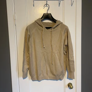 Beige stickad merinoulls hoodie  - En trevlig och väldigt mjuk merinoull hoodie. Har aldrig använts, bara testat en gång, då den inte passar. Är egentligen storlek medium men passar snarare som en small.   Är generös vid snabb affär.