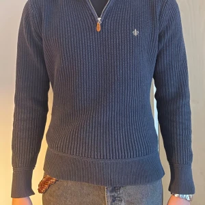 Svart stickad half zip-tröja Morris - Svart stickad tröja från Morris i storlek M. Tröjan har ribbad struktur, lång ärm och en half zip-dragkedja framtill. Liten broderad logga på bröstet. Perfekt för dig som gillar klassisk stil med en modern touch. Modellen är 181cm 70kg. Skriv vid frågor 💪