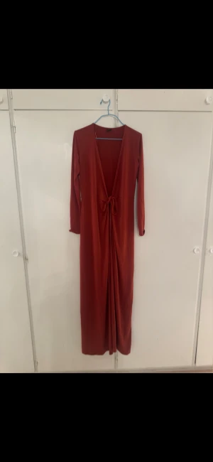 långklänning / cardigan - Röd/brun lång klänning/cardigan. Knyt snöre i mitten som kan knytas på olika sätt. Lång till fötterna. Storlek s. Gina tricot. Kan användas som både klänning eller cardigan