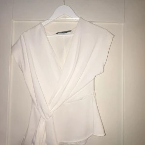 Vit omlottopp från Zara XS - En jätte fin topp från Zara som är använd fåtal gånger. har två fläckar som knappt syns, kolla bilderna🫰 skriv vid frågor🥰