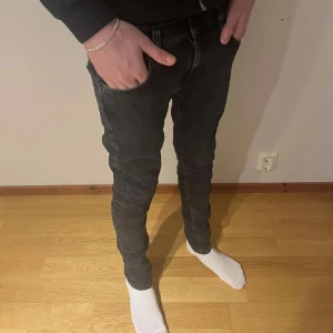 Nudie jeans - Svarta jeans från Nudie Jeans med klassisk femficksdesign och snygga detaljer på bakfickorna. Jeansen har en slim passform och är tillverkade i stretchig denim för extra komfort. Perfekta för dig som gillar en smal siluett och stilren look.