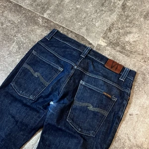 Dry Nudie Jeans - Straight Fit - Sjukt feta nudies med ett mindre hål i skrevet som går obemärkt vid användning! Dessa har ett långt liv kvar och om hålet är för jobbigt är det gratis att laga på nudies affärer:) 