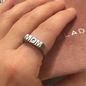 Edblad silverring MOM - Cool och stilren ring från Edblad i blankt silverfärgat material. Ringen har texten MOM. Perfekt statement-piece med chunky känsla och tydliga bokstäver.