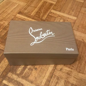 Mörkblå sneakers från Christian Louboutin - Snygga mörkblå sneakers från Christian Louboutin med klassisk rund tå och platt sula. Skorna har snörning och är tillverkade i lyxig mocka med den ikoniska röda sulan. Insidan är beige och ger en exklusiv känsla. Perfekta för dig som gillar stilrena designer.