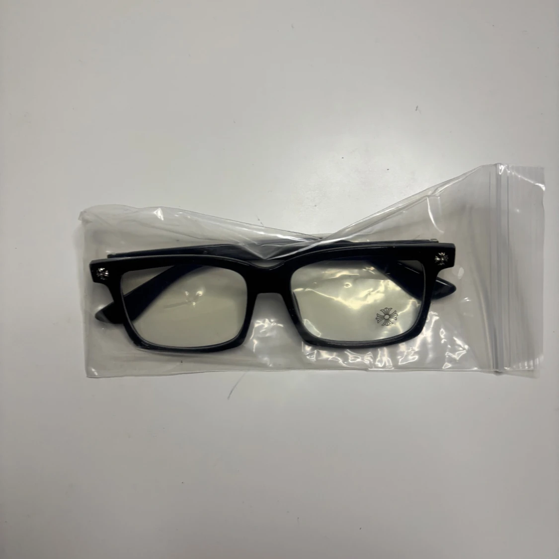 Svarta rektangulära glasögon med blommig detalj