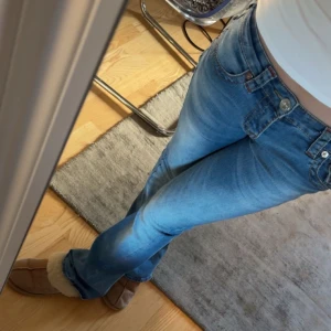 True Religion ljusblå becca bootcut jeans - Säljer ett par ljusblå jeans från True Religion med klassiska kontrastsömmar och snygga detaljer på bakfickorna. Modellen har låg midja och bootcut-ben, samt silverfärgade knappar och logopatch bak. 💖org pris = 1600