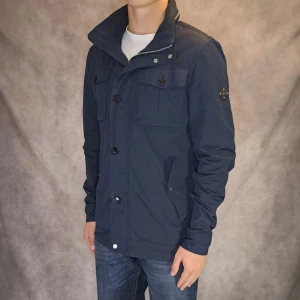 Bailey Field Jacket - J-Lindeberg - Stl M - | Snygg och eftertraktad field jacket från J-Lindeberg i Marinblå färg | Mycket bra skick: 9/10, endast en mini fläck på baksidan som inte märks av om man inte tittar noggrant | Stl: M | Modellen är 175cm lång, men passar längre |