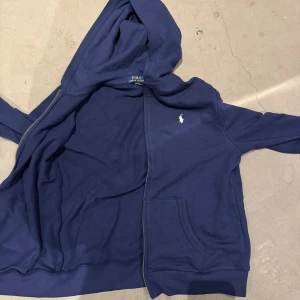 Zip hoodie polo marinblå - Säljer marinblå hoodie från polo i storlek 176. Använd några få gånger men har nu växt ut tröjan. Bra skick!