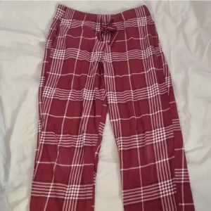 Röd-rutiga mjukisbyxor Kappahl XS - Snygga röd-rutiga byxor från Kappahl i storlek XS. Byxorna har vitt rutmönster, elastisk midja med snörning och är gjorda i mjuk bomull. Passformen är någor kortare, skriv om ni vill ha specifika mått. Använt endast ett fåtal gånger, men i mycket bra skick. Nypris runt 200 kr. Populära! Ser ut som nya fast använda.