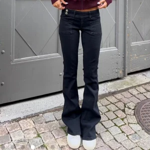 Svarta bootcut jeans med broderade fickor - Snygga svarta jeans med bootcut passform och låg midja från Gina. Storlek s