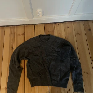 Mörkgrå stickad tröja från Uniqlo - Säljer en mörkgrå stickad tröja från Uniqlo i storlek S. Tröjan har rund hals och långa ärmar med ribbade muddar vid ärmslut och nederkant. Perfekt för dig som gillar enkel och stilren design med en chill vibe.