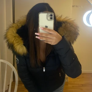Svart vinterjacka med päls, Rockandblue - Perfekt för kalla dagar och riktigt snygg passform. Mysig vinterjacka från Rockandblue med stor huva och fluffig fuskpäls i gult och svart. Knappt använd, nästan som ny.  (PRIS KAN DISKUTERAS)