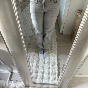 Grå baggy/straight jeans från Gina tricot - Snygga ljusgrå jeans från Gina tricot  i baggy/rak modell. Klassisk femficksdesign och normal passform. Jeansen har hög midja och är tillverkade i ett mjukt bomullsmaterial som ger en avslappnad vibe.
