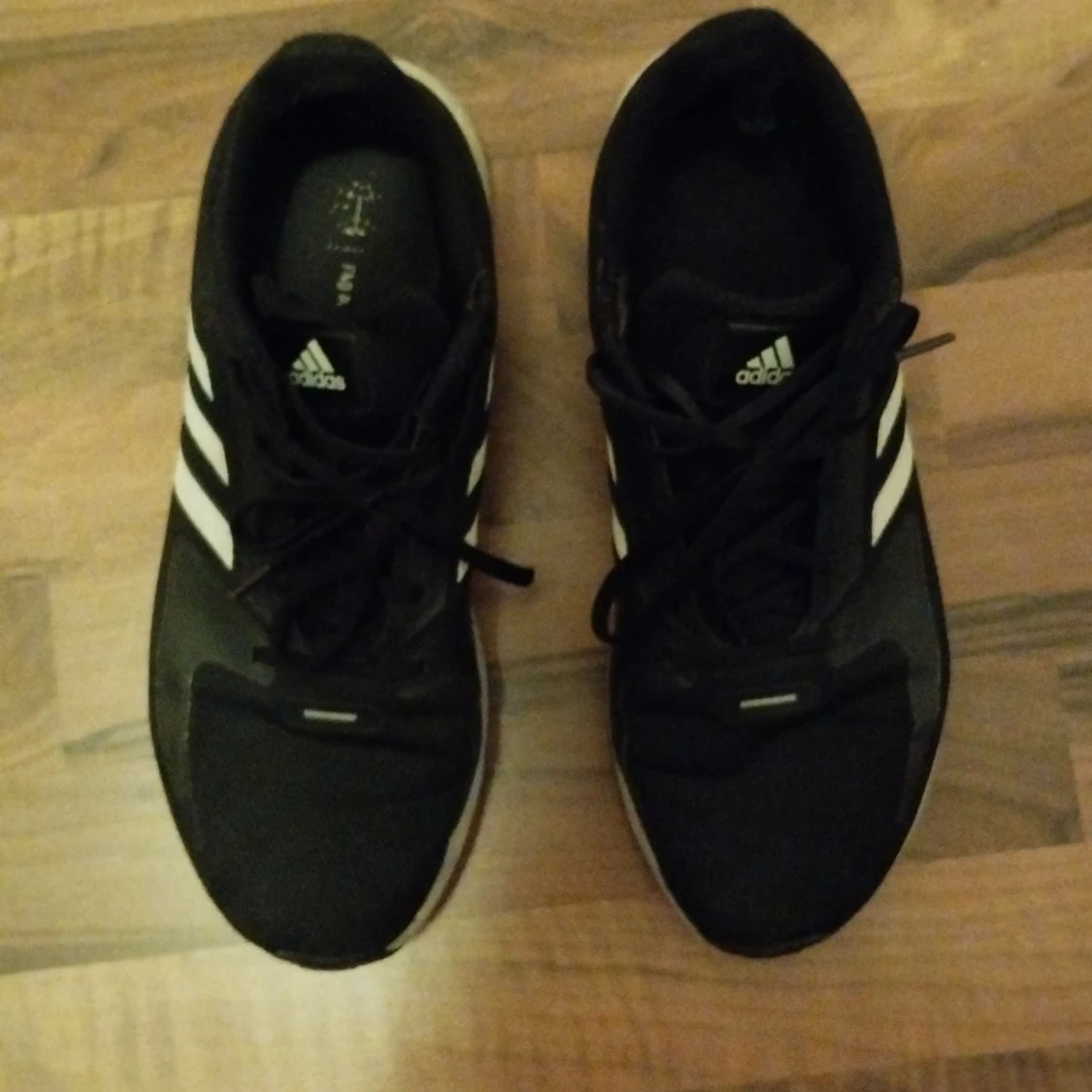 Svarta Adidas sneakers med vita ränder