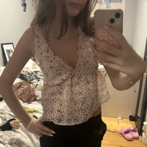 Rosa topp - Rosa topp med blommor. Jättefin och somrig💕 man knyter banden så man kan justera hur lång/kort den ska vara💕