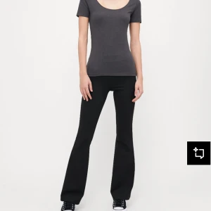 Mörkgrå t-shirt från Anna Field - En basic mörkgrå t-shirt från Anna Field med rundad, djup urringning och korta ärmar. Modellen är figurnära och passar perfekt till jeans eller kjol. Tillverkad i mjuk bomull för en skön känsla hela dagen.