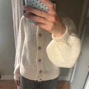 Beige stickad kofta  - Suppergullig beige stickad kofta, men ganska puffiga ärmar! Något stickig men annars varm och skön!  