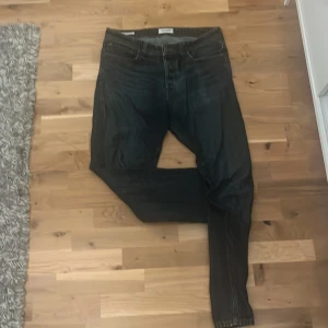 Mörkblå raka jeans från Jack & Jones  - Säljer ett par klassiska mörkblå jeans från Jack & Jones med rak passform. Jeansen har fem fickor, normal midja och är tillverkade i slitstarkt denim. Perfekta för dig som gillar en tidlös och enkel stil. Storlek - 32/34