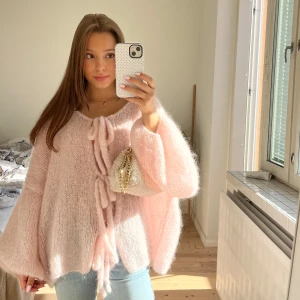 Handmade ljusrosa fluffig kofta med knyt - HANDMADE! ⭐️Supermysig och oversized ljusrosa kofta med fluffig känsla. Koftan har breda ärmar och knyt framtill som ger en söt och trendig look. Perfekt att slänga på sig över ett linne eller t-shirt. Känns lyxigt och cozy. Hemgjord och endast använd ett par gånger. Tillverkad av mohairgarn som inte kliar när det är på. 🥰🥰Passar storlek XS-L