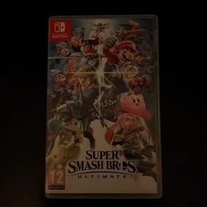 Super Smash Bros. Ultimate - Super Smash Bros. Ultimate till Nintendo Switch. Komplett med fodral och spelkort. Spelet är i mycket gott skick, med omslag och inlaga i fint skick. Perfekt för både solo och multiplayer med över 70 spelbara karaktärer.