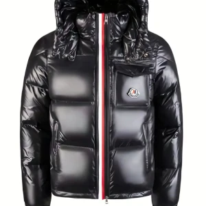 Svart dunjacka från Moncler med huva lite suddiga bilder men! - Säljer en svart helt ny, glansig dunjacka från Moncler med huva och ikonisk logga på bröstfickan. Jackan har quiltad design, rödvit randig dragkedja och en boxig passform. Perfekt för kalla dagar när du vill hålla stilen och värmen.