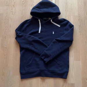 Marinblå Ralph Lauren Hoodie - Hej, Säljer nu denna riktigt feta polo ralph lauren hoodien. Jag köpte den på plick för ett tag sedan för 720kr men nu är den för liten för mig och säljer därför den. Den är i S men passar någonstans mellan XS och S. Modellen på bilden är 183cm och väger 74kg. Skulle nog säga att den passar perfekt på någon runt 170! Ställ gärna frågor och priset går att diskutera. OBS finns en liten defekt, se bilden. Går nog att sy ihop rätt så lätt. 