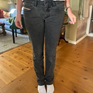 Svarta Diesl bootcut jeans - Säljer ett par svarta Diesel jeans med bootcut passform. Jeansen är lågmidja och är tillverkade i mjukt denimtyg som ger en skön känsla.