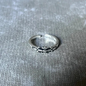 Kors ring - Minimalist ring with a finely carved Fleur de Lis, adding subtle depth while remaining sleek and bright