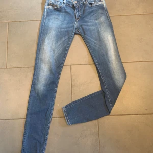 Replay Hyperflex skinny jeans blå - Säljer ett par Replay Hyperflex jeans i klassisk blå tvätt med snygga slitningar. Modellen är skinny fit med normal midja och fem fickor. Jeansen har stretchigt material för extra komfort och coola detaljer på bakfickorna.