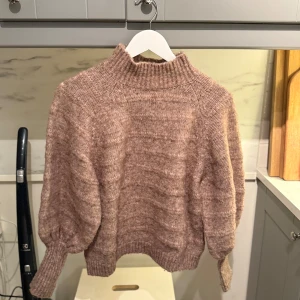 Beige stickad tröja med hög krage - Mysig beige stickad tröja med hög ribbad krage och ballongärmar från Only.
