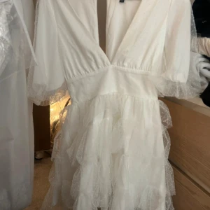 Vit volangklänning med prickigt tyll - Vit tyllklänning från lulu’s. Använd en gång. Strl S. Perfekt till studenten!