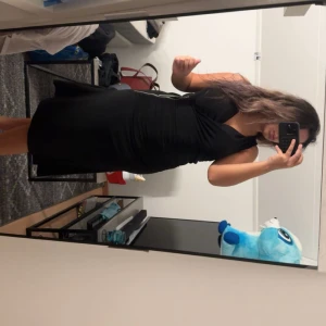 Svart omlottklänning Michael Kors M - Svart omlottklänning från Michael Kors i storlek M. Klänningen är ärmlös med v-ringning och har en snygg dragkedjedetalj på sidan. Figurnära passform och mjukt, stretchigt material som sitter riktigt snyggt.