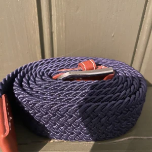 Flätat bälte 100 cm - Säljer ett mörkblått bälte som knappt har använts något. 100 cm. Kan posta inom 2 dagar.