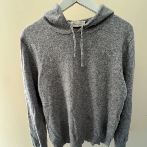 Grå kashmirhoodie från Sayless - Bekväm och stilren grå hoodie från Sayless i 100% kashmir. Tröjan har huva med snörning och långa ärmar. Den är i storlek L men sitter som S/M, säljer då den blivit för liten för mig 