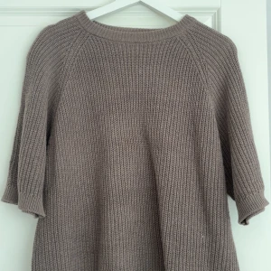 Beige stickad tröja från 157, XS - Säljer en beige stickad tröja från 157 i storlek XS. Tröjan har en avslappnad passform, rund halsringning och ribbade muddar vid ärmslut och hals. Perfekt för lager-på-lager och chill dagar.