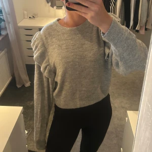 Grå stickad tröja med volangdetalj - Superfin grå stickad tröja med volangdetaljer 