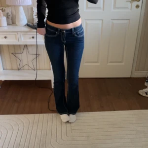Y2K Low bootcut jeans - ”Y2K low bootcut jeans” från Gina Tricot. Mörkblåa med vita sömmar. Inte kommit till användning. Nypris 499.95kr.