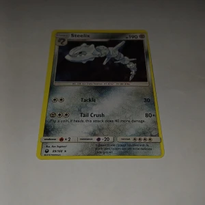 Steelix - Coolt Pokémonkort med Steelix! Perfekt för dig som samlar eller spelar Pokémon TCG. Kortet har snygg design och visar Steelix i action med attacker som Tackle och Tail Crush. Ett måste för alla Pokémon-fans och samlare!