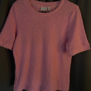 Rosa stickad topp från Vila - Supersöt rosa stickad topp från Vila med korta ärmar och rund hals. Fint hålmönster över hela tröjan och vågig kant vid hals och ärmslut. Jätte fin och perfekt till hösten. Säljs för att den inte kommer till användning. Kontakta för egna bilder.