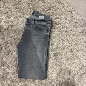 Jeans från jack n jones - Gråa jeans från jack n jones. Ett hål vad bakficken som man ser på tredje bilden därav priset.