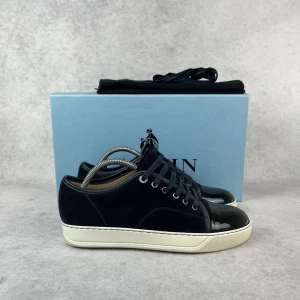 LANVIN DBB1 CAP TOE SNEAKER - – Condition: 9,5/10 - used twice  - Size: 39/UK5  – What is included: Dustbag  – Retail price: 5000 + SEK  Please note that Lanvins fit big and our recommendation is to go one size down
