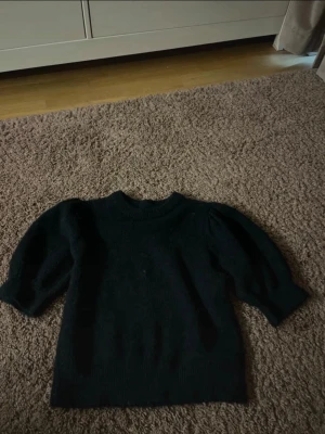 Mörkblå stickad tröja Gina Tricot - Mörkblå stickad tröja från Gina Tricot med puffiga ärmar och ribbade muddar.