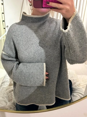 Grå stickad polotröja med vida ärmar - Super snygg grå polo tröja med vita detaljer! 