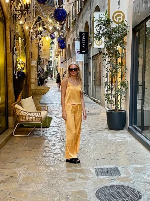 Tvådelat satinset - linne och byxa  - Snyggt set i en fin orange färg med smala och justerbara axelband och v-ringning, dekorerad med spetsdetaljer framtill. Glansigt satinliknande material som ger en lyxig känsla 🌼Byxor med resår i midjan. Jag har vikt in linningen för att de var lite för långa på mig. Passat personer som är längre än 163cm. Publicerad på flera säljsidor. Säljes endast som set.