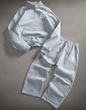 Gråa mjukisbyxor med tryck - Säljer ett par gråa mjukisbyxor med bred passform och resår i midjan. Byxorna har ett vitt tryck på ena benet och är gjorda i mjukt bomullsmaterial. Perfekta för chill dagar eller när du vill ha det bekvämt.