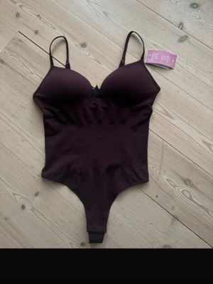 Vinröd  body från H&M - Säljer den populära hm bodyn i vinröd helt ny prislapp kvar bara testad ser lite mer choklad brun ut i verkligheten 