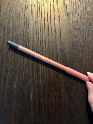 Huda Beauty Lip Contour 2.0 läppenna - Säljer en Huda Beauty Lip Contour 2.0 läppenna i en snygg nude-rosa nyans. Pennan har en matt finish och är enkel att applicera tack vare sin krämiga formula. Perfekt för att definiera och forma läpparna. Snygg och stilren design med lock.   Full size. Nästan helt ny då färgen inte passade mig. 